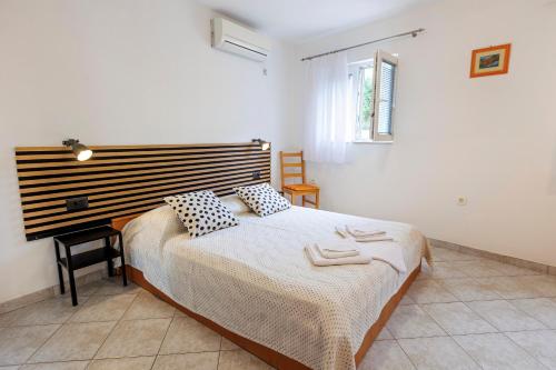 a bedroom with a large bed and a desk at Apartments Baričević in Bol