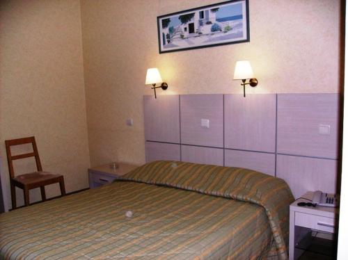 1 dormitorio con cama, escritorio y silla en Hotel Pantheon, en Pyrgos