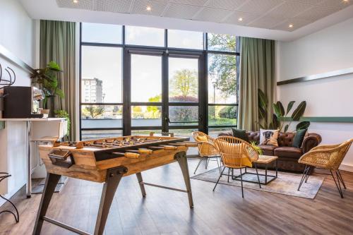 a living room with a ping pong table and chairs at ibis Paris CDG Airport in Roissy-en-France