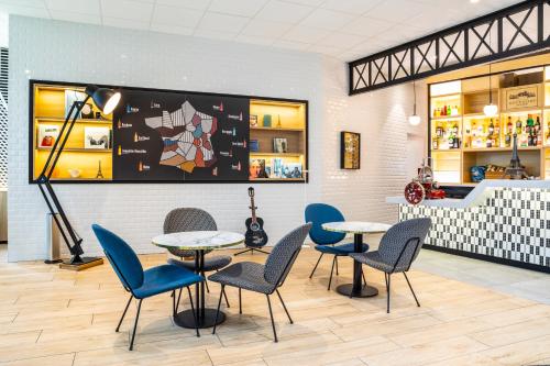 a restaurant with tables and chairs in a room at ibis Paris CDG Airport in Roissy-en-France