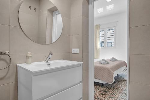 a bathroom with a sink and a mirror and a bed at Apartamento Guzmán B in Barbate