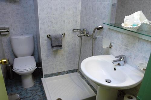 a bathroom with a toilet and a sink at Hotel Pantheon in Pýrgos