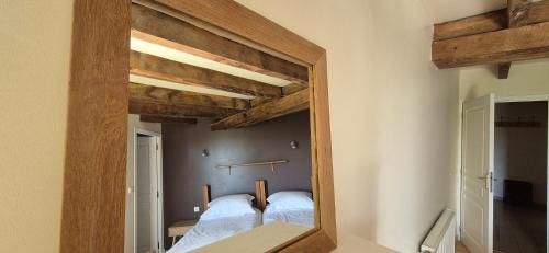 a mirror in a room with a bed in it at La Grange - Gite Mur de Barrez in Mur-de-Barrez