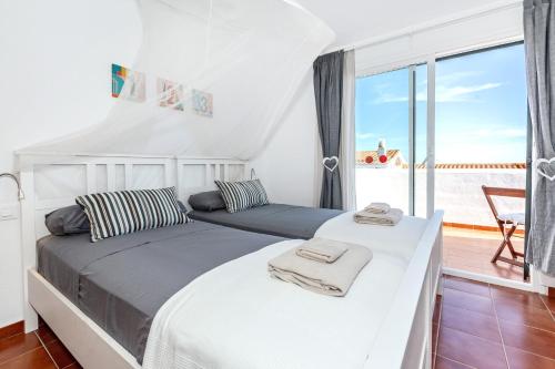 Un dormitorio con dos camas con vista al mar. en Maison Menorca, en Arenal d'en Castell
