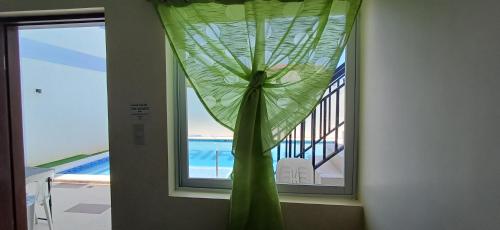 a window with a green curtain in a room at Sakura's Pool and Leisure Hub in Puerto Princesa City