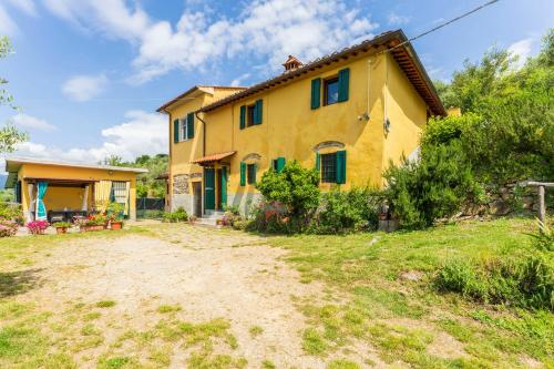 a large yellow house with a yard in front of it at La Casa Di Elda, Holiday Home With Pool, Uzzano, Toscana in Uzzano