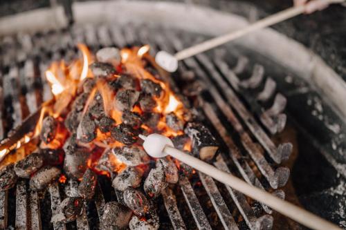 a person is cooking food on a grill at ASTER Boutique Hotel & Chalets in Fügenberg