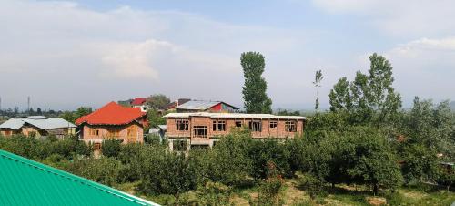 a group of houses on a hill with trees at magray guest house in Gulmarg