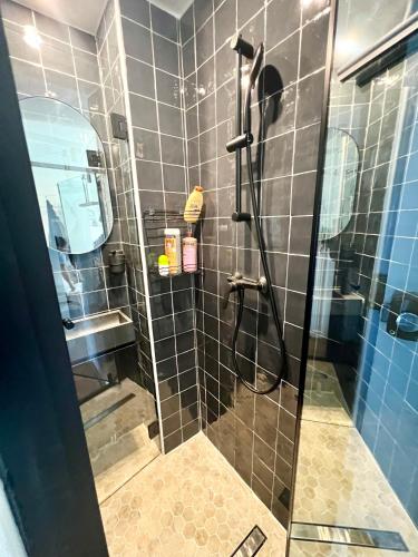 une douche avec une porte vitrée dans une salle de bain dans l'établissement Séjour parisien Suite Bastille, à Paris