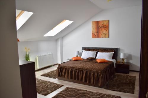 sypialnia z łóżkiem z pomarańczowymi poduszkami w obiekcie Enjoy Apartments - Skyview Residence w Klużu-Napoce