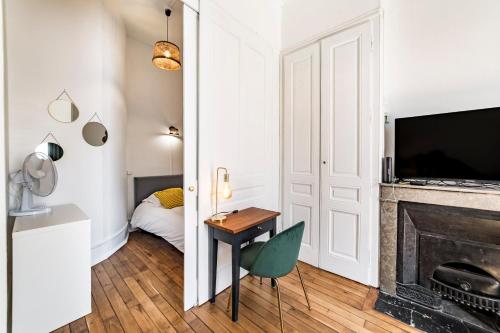 - un salon avec une cheminée et une table avec une chaise dans l'établissement Lyon 6 / Villeurbanne refait à neuf en 2024, à Lyon