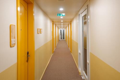 a long hallway with yellow and white walls at Bloom Boutique - Connaught Place Area in New Delhi