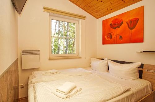 een slaapkamer met een bed met twee handdoeken erop bij Chalet Ostsee Haus Nr. 72 in Göhren