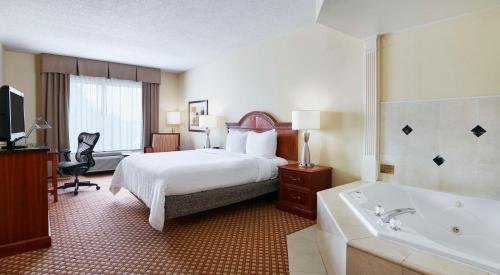 Habitación de hotel con cama y bañera en Hilton Garden Inn Charlotte North, en Charlotte