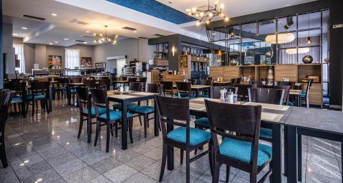 una sala da pranzo con tavoli e sedie in un ristorante di Best Western Airport Hotel Stella a Zagabria