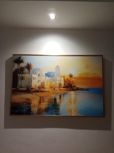a painting of a beach with buildings and palm trees at La Cascade Ḩammām al Ghazzāz in Kelibia