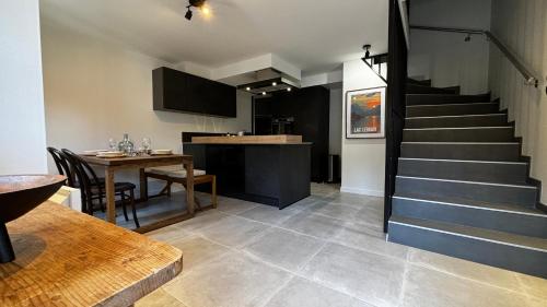 une chambre avec un escalier, une table et une salle à manger dans l'établissement Escapade au coeur d'Yvoire, à Yvoire