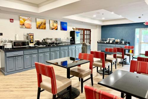 Comfort Suites East Brunswick - South River في إيست برونزويك: مطعم بطاولات وكراسي وكاونتر