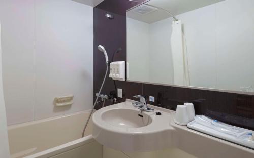 a bathroom with a sink and a mirror at Comfort Hotel Hakata in Fukuoka