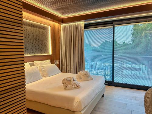 a bedroom with a bed with towels on it at Alevic Hotel Sirmione in Sirmione