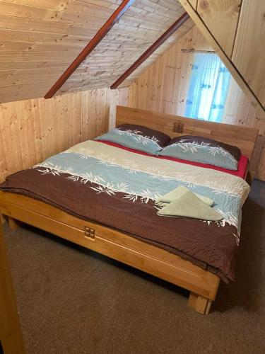 a bed with a wooden frame in a room at Penzion chalupa Lesní zátiší in Harrachov