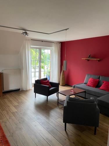 a living room with a couch and a red wall at Ferienhof Kröger in Bielefeld