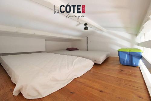 une chambre avec deux lits et une poubelle bleue dans l'établissement Atlante, à Sausset-les-Pins