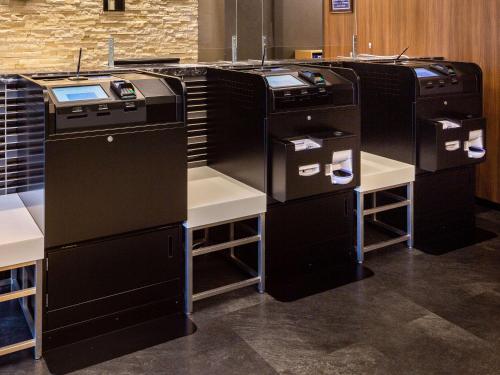 a row of black appliances in a room at Comfort Hotel Maebashi in Maebashi