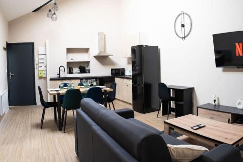 a living room with a couch and a table and a kitchen at L'ÉLÉGANT Appartement Climatisé à 300m du Théâtre Antique in Orange