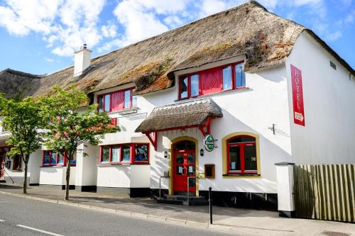a white building with a thatched roof at Idyllic, 5 Star Family Home with Panoramic Views, Kinvara on the Wild Atlantic Way in Kinvara