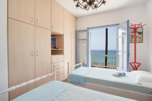 a bedroom with two beds and a window with the ocean at Orkos View House in Plaka