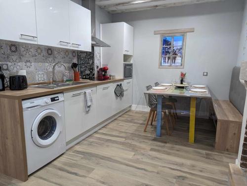 une cuisine avec une machine à laver et une table dans l'établissement Madaiv à 5 mn de Beauval & proche des châteaux, à Seigy