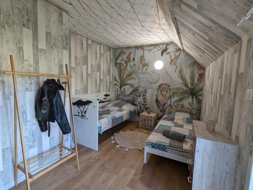 une chambre avec deux lits superposés et un mur avec des animaux dans l'établissement Madaiv à 5 mn de Beauval & proche des châteaux, à Seigy