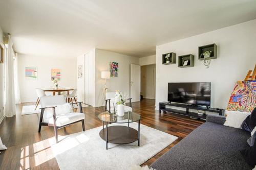 ein Wohnzimmer mit Sofa und Fernseher in der Unterkunft Appartement avec Terrasse, Parking et WiFi, DisneyLand Paris in Chessy