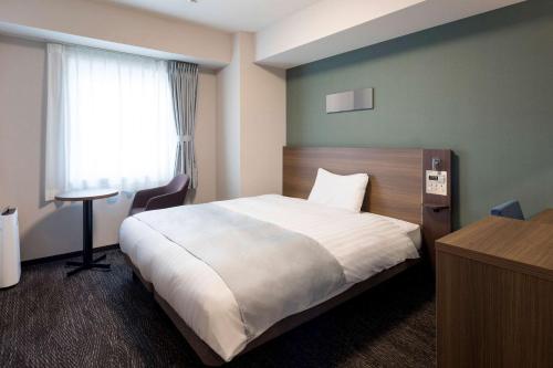a hotel room with a bed and a window at Comfort Hotel Tokyo Higashi Kanda in Tokyo