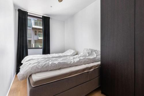 a bed in a bedroom with a window at Superb apartment by Opera house in Oslo