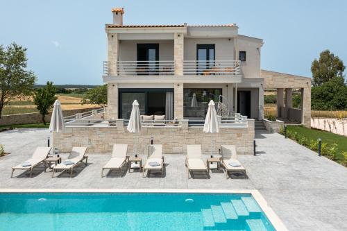 a villa with a swimming pool and a house at Black Lotus Pool Villa, Afitos #FeelsLikeHome in Afitos