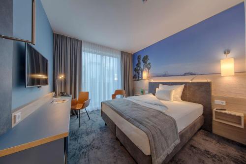 Best Western Hotel Wiesbaden في فيسبادن: غرفة فندق بسرير وجدار ازرق