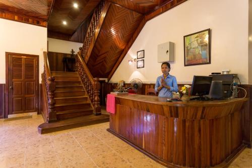 a man sitting at a desk in a room at Le Tigre Hotel in Siem Reap
