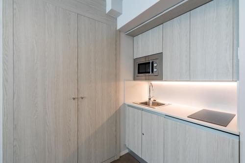 - une cuisine avec des placards blancs et un évier dans l'établissement Residencia Universitaria Claudio Coello, à Madrid