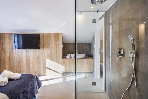 a bathroom with a shower and a bed and a television at Incredibly beautiful Stone House Villa Lota - Makarska Exklusiv in Bast