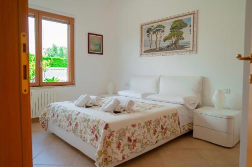 une chambre blanche avec un lit et une fenêtre dans l'établissement Villa Rosa - Holiday Home, à Polignano a Mare