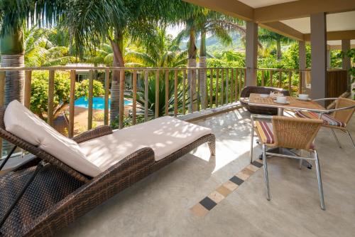 a porch with a couch and a table and a pool at The Rusty Pelican in La Gaulette