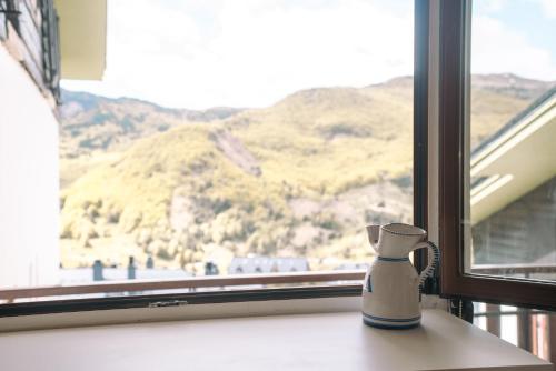 a vase on a window sill with a view of a mountain at Apartamento en Formigal luminoso con balcón y vistas in Formigal