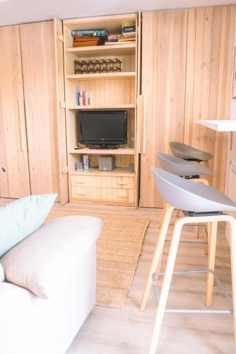 a living room with a tv and a chair at Apartamento en Formigal luminoso con balcón y vistas in Formigal