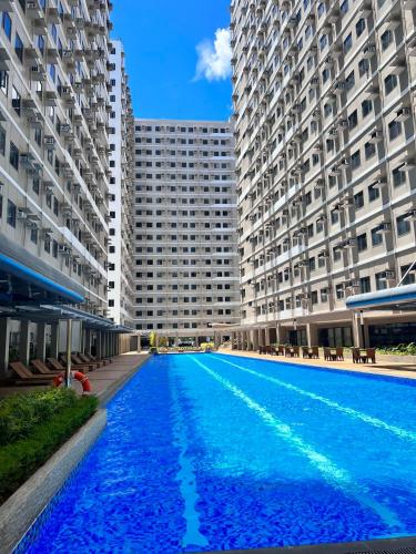 a large swimming pool in the middle of two buildings at SMDC Green 2 Staycation, The Traditional & Modern Fusion Condo in Pasong Bayog
