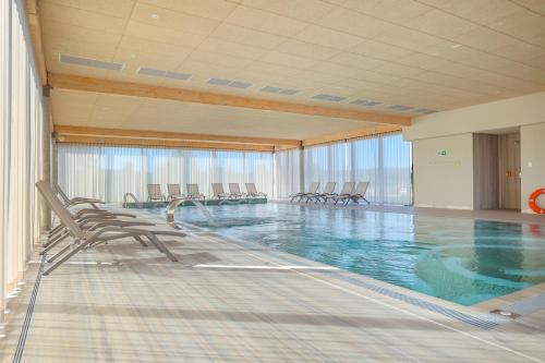 una grande piscina con sedie in un edificio di Hotel GLAR Conference & SPA a Wisełka