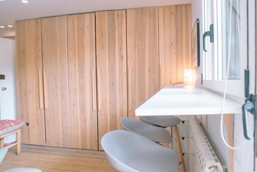 a room with a white table and chairs and wooden cabinets at Apartamento en Formigal luminoso con balcón y vistas in Formigal