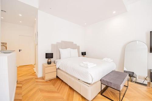 une chambre blanche avec un lit et un miroir dans l'établissement New Duplex 4Pers#Porte Maillot#Porte Champerret, à Paris