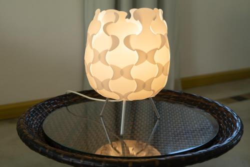 a lamp sitting on top of a glass table at The Rusty Pelican in La Gaulette
